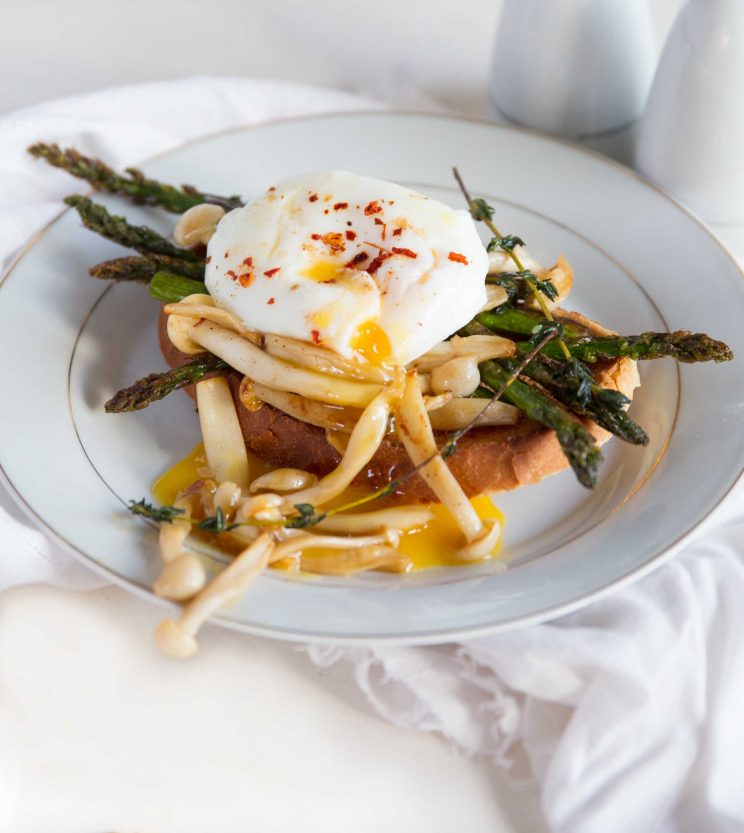 closeup shot of poached egg on toast with asparagus